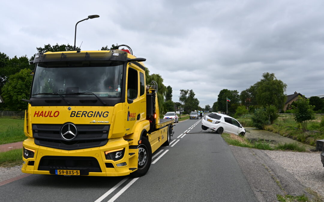Geparkeerde auto rolt het water in tijdens kopen van bloemen in Heerhugowaard.